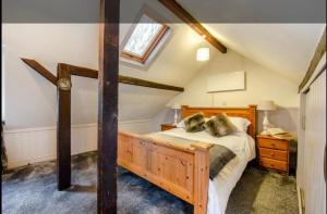 a bedroom with a wooden bed in a attic at Stable boys cottage in Sedgeberrow