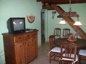 ein Esszimmer mit einem TV und einem Tisch mit Stühlen in der Unterkunft La casita de Loly in Carilo