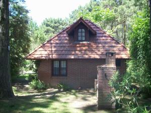 ein kleines Backsteinhaus mit Schindeldach in der Unterkunft La casita de Loly in Carilo