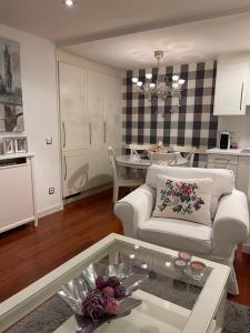 een woonkamer met een witte bank en een tafel bij Apartamento Balcón a la Basílica del Pilar in Zaragoza