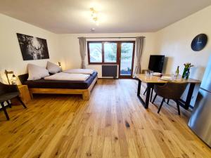 ラドルフツェル・アム・ボーデンゼーにあるSeemöwe - moderne Wohnung mit Balkonのリビングルーム(ベッド1台、デスク、テーブル付)