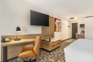a hotel room with a bed and a desk with a television at Hampton Inn Atlanta-Stockbridge in Stockbridge