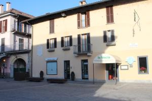 a large building with benches in front of it at Like Home mono 2 in Sesto Calende