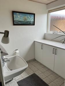 a bathroom with a sink and a bath tub at Dejlig og hyggelig hus i Thyborøn in Thyborøn +27 photos