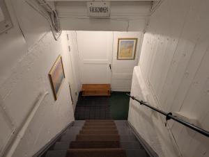 a hallway with stairs and a white door and a sign at Prisvärt semesterboende in Vadstena