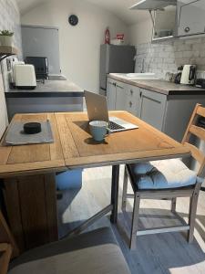a kitchen with a wooden table with a laptop on it at Willden Cottage in Holmfirth +38 photos