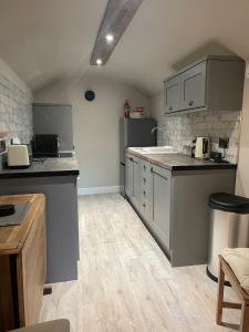 a kitchen with gray cabinets and a counter top at Willden Cottage in Holmfirth