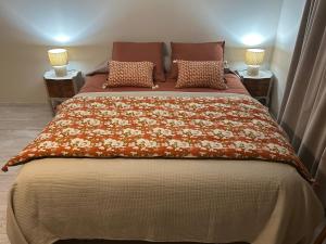 a bed in a bedroom with two lamps on two tables at Chatimbarbe in Yssingeaux