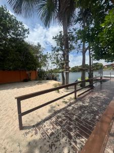 a wooden bench sitting on the beach next to the water at CAsA LENÇOIS 39 in Barreirinhas