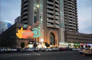 a large building with cars parked in a parking lot at Familiar Partition Room In Tecom Near ICM Metro in Dubai
