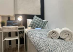a bedroom with a bed with towels on it at Familiar Partition Room In Tecom Near ICM Metro in Dubai