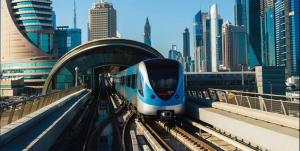 a blue and white train on the tracks in a city at Familiar Partition Room In Tecom Near ICM Metro in Dubai