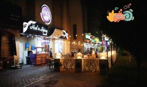 a restaurant with lights on a street at night at Familiar Partition Room In Tecom Near ICM Metro in Dubai