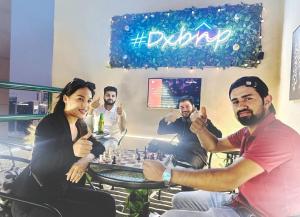 a group of people sitting around a table playing chess at Familiar Partition Room In Tecom Near ICM Metro in Dubai