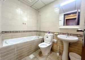 a bathroom with a tub and a toilet and a sink at Familiar Partition Room In Tecom Near ICM Metro in Dubai
