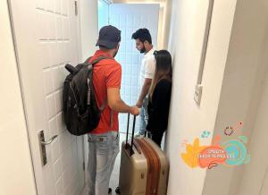a group of people standing in a hallway with luggage at Familiar Partition Room In Tecom Near ICM Metro in Dubai
