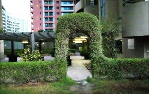 an arch covered in ivy next to a building at Familiar Partition Room In Tecom Near ICM Metro in Dubai