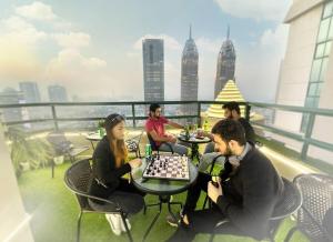 a group of people playing chess on the roof of a building at Familiar Partition Room In Tecom Near ICM Metro in Dubai