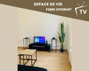 a living room with a tv and a table at Room 203 Hyper Proche Gare 250m in Montargis