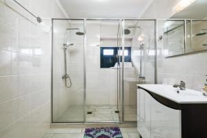 een badkamer met een glazen douche en een wastafel bij Casa da Avó Paraíso 1 in Machico