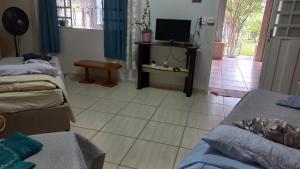 un soggiorno con 2 letti e una TV di Sossegoterapia a Casa Branca