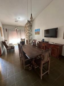 een eetkamer met een tafel, stoelen en een televisie bij Casa en Villa Carlos Paz in Villa Carlos Paz