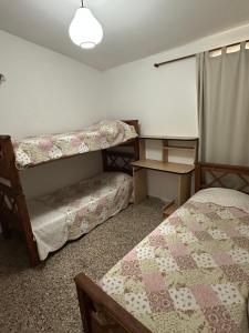 een kamer met 2 bedden, een bureau en een tafel bij Casa en Villa Carlos Paz in Villa Carlos Paz +10 foto's