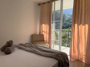 a bedroom with a bed and a chair and a window at Montes De Beraka in Minca