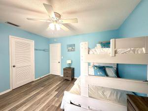 a bedroom with blue walls and a ceiling fan at Anna Maria Island Beach Front Condo - 50 steps to Beach in Holmes Beach