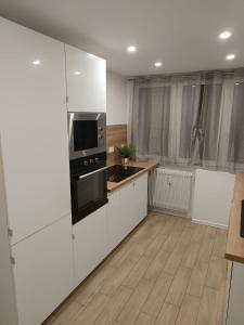 una cucina con mobili bianchi e un microonde nero di Superbe Appartement ! a Saint-Étienne