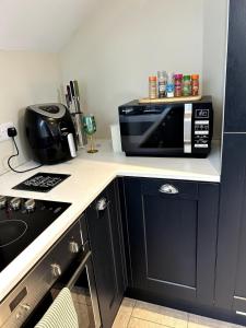 a kitchen with a microwave on a counter top at The Burrow in Glenoe