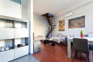 Una sala de estar con una mesa y un dormitorio. en Heart of NoLo - Meryggiare Apartments, en Milán