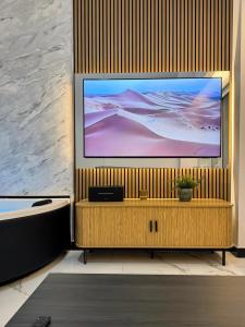 TV de pantalla plana grande en una pared de madera en Spa Suite with Jacuzzi and Ancient Theater View, en Larisa