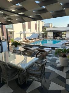 un patio con tavoli, sedie e piscina di Apartments Laura 1 a Privlaka (Brevilacqua)