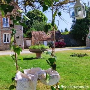 een tuin met een huis op de achtergrond bij Domaine de la Ferme de Mont in Mormant