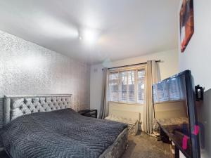 un dormitorio con una cama y una ventana en house with hot tub, en West Derby
