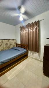 a bedroom with a bed and a curtain in a room at Casa com piscina em Bertioga 700m da praia in Bertioga