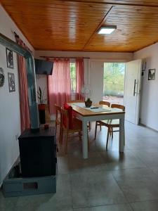 a living room with a table and chairs and a stove at cabañas Saona in Molinari +23 photos