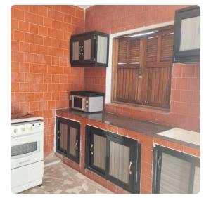 a kitchen with a microwave and a brick wall at Entrenous in Leclerc