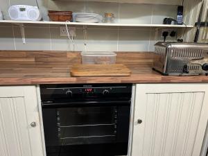 a kitchen with a counter top with a black oven at Teach Cruachan Large-Group Holiday Home in Dooagh
