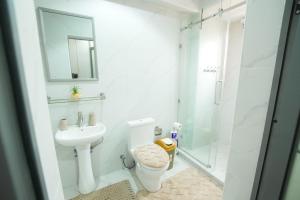 Un baño blanco con inodoro y ducha. en Kenji with Balcony & Gym 410, en Oyarifa 22 fotos más