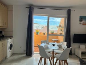a dining room with a table and chairs and a window at Ático centro Tarifa in Tarifa