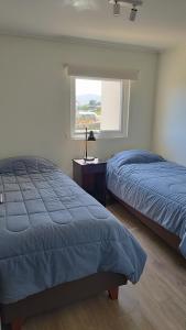 due letti in una camera da letto con finestra di Precioso departamento con vista a la playa a Papudo