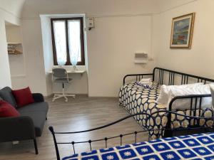 a living room with two beds and a couch and a room with a couch at Appartamentino nel castello in Miglianico