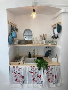 a kitchen with a sink and a shelf with utensils at Appartamentino nel castello in Miglianico