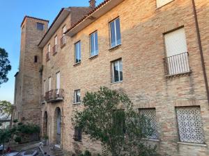 an old brick building with a tree in front of it at Appartamentino nel castello in Miglianico