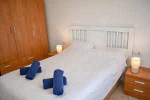 a bedroom with two blue towels on a white bed at Ático centro Tarifa in Tarifa