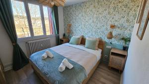a bedroom with a bed with towels on it at Ô Rives du Doubs - La campagne à la ville in Pontarlier