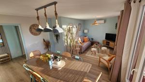 a living room with a table and a couch at Ô Rives du Doubs - La campagne à la ville in Pontarlier