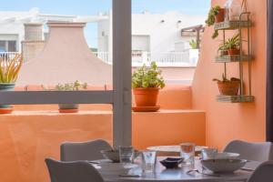 a table in a restaurant with a view of a balcony at Ático centro Tarifa in Tarifa